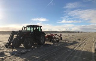 Loonbedrijf+harkt+strand+Terschelling+schoon